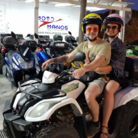 moto manos customers posing for photo on a white quad in front of our office in perissa santorini